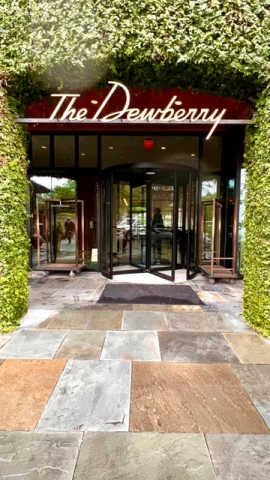 A sign reading "The Dewberry" sits beneath a leafy hedge