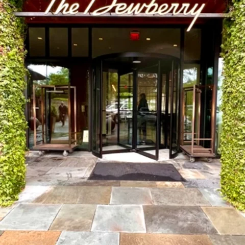 A sign reading "The Dewberry" sits beneath a leafy hedge