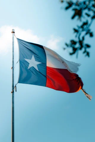 Texas flag with a blue sky in the background