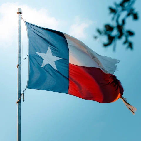 Texas flag with a blue sky in the background