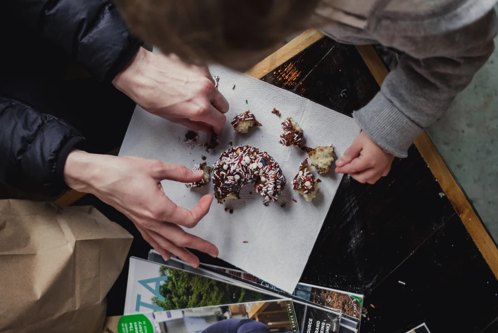 A picture of a two people eating donuts.