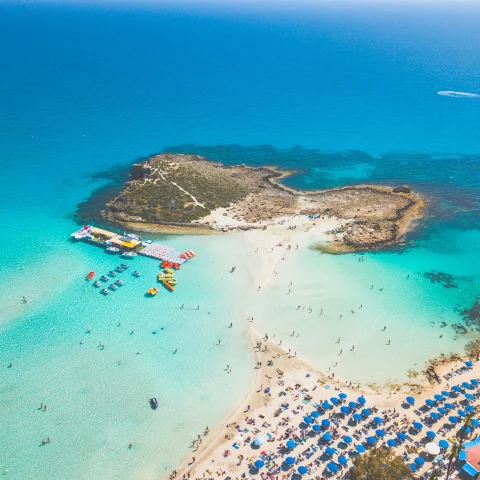 An aerial view of beach with clear blue water