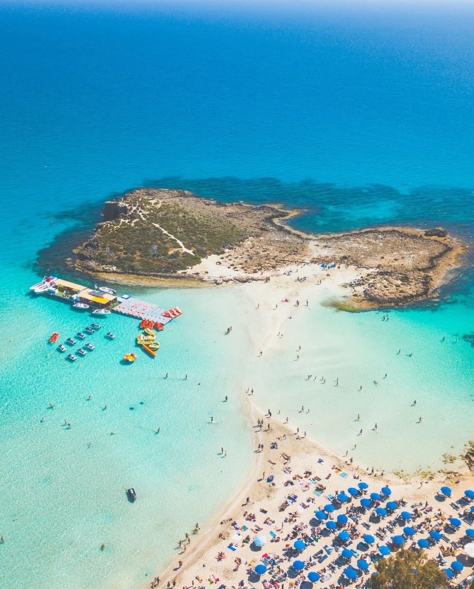 An aerial view of beach with clear blue water