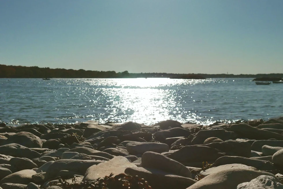 rocky shore and bright sun on the ocean