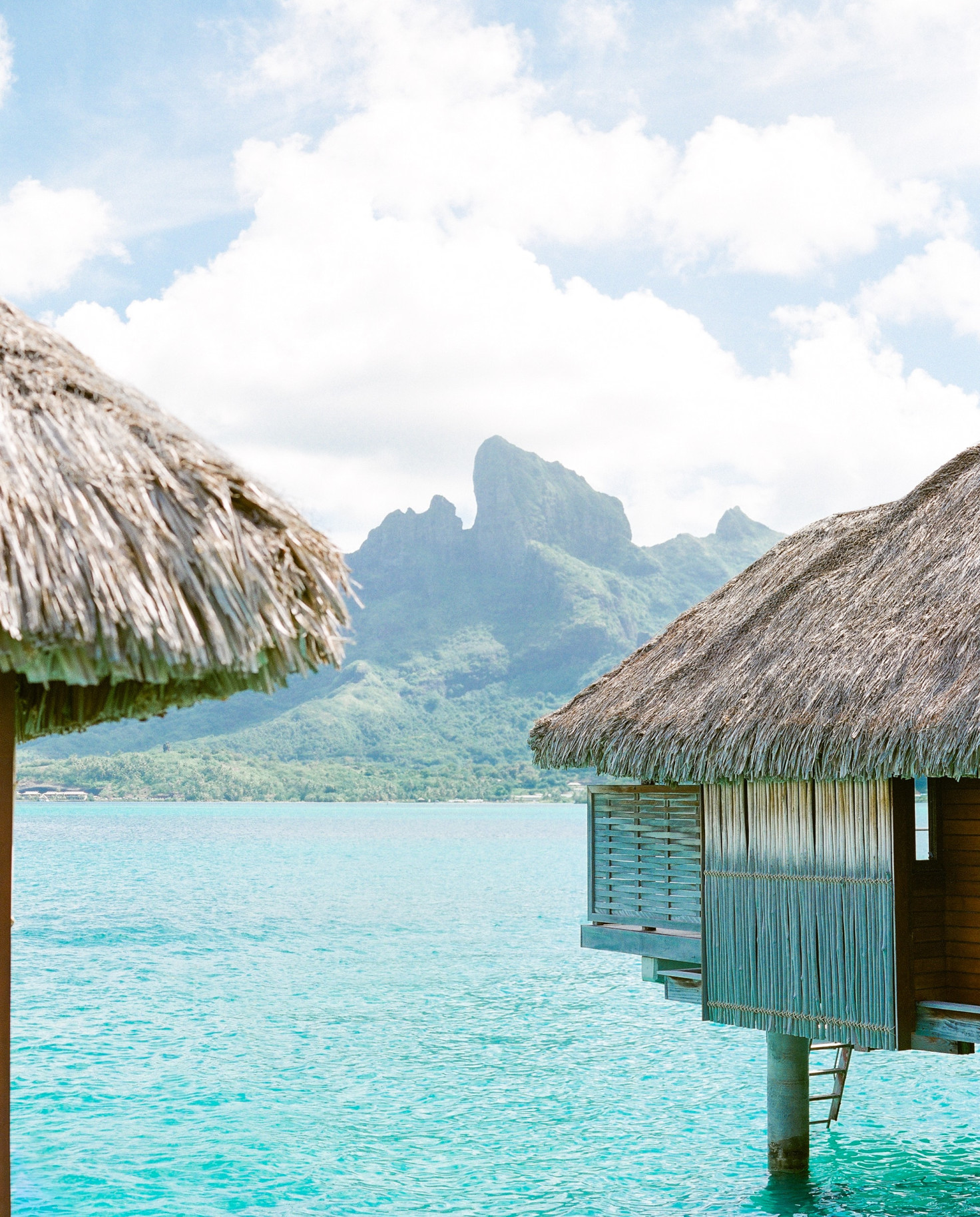 Hut on body of water with mountain in background during daytime