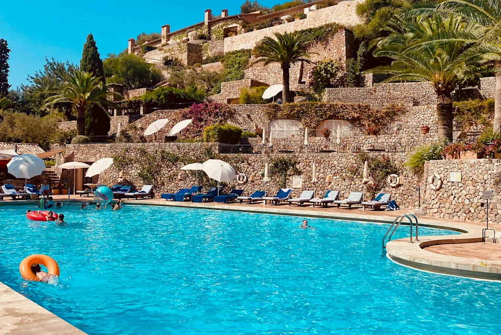 Pool next to brick wall and tan building during daytime