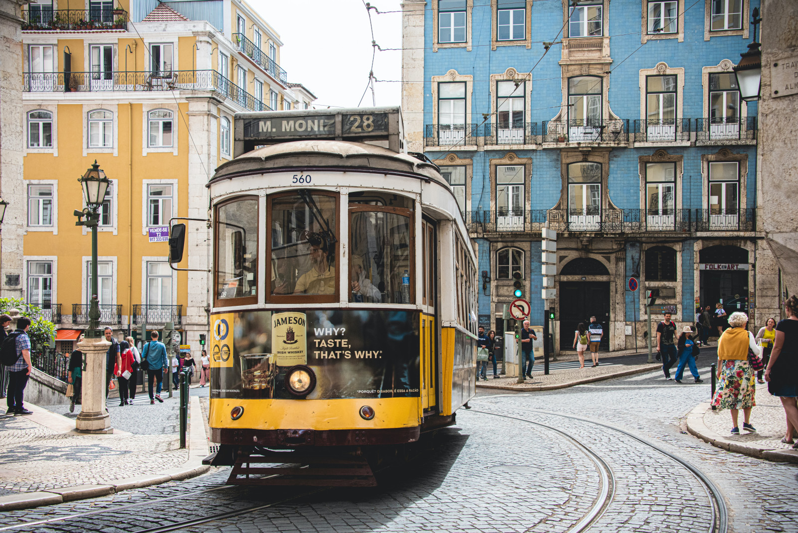 trolley car on street with people walking during daytime