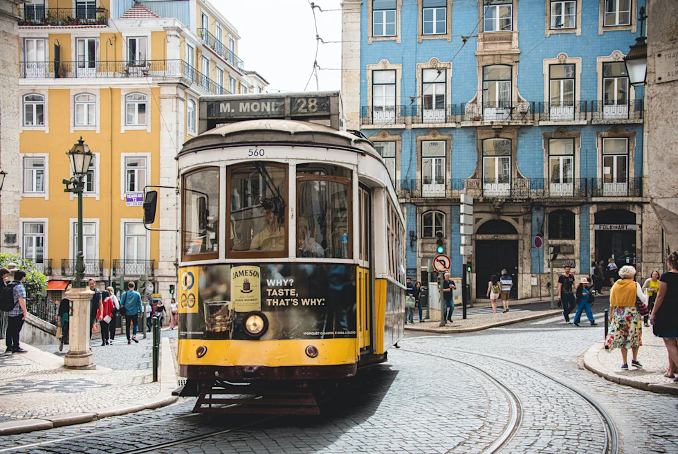 trolley car on street with people walking during daytime