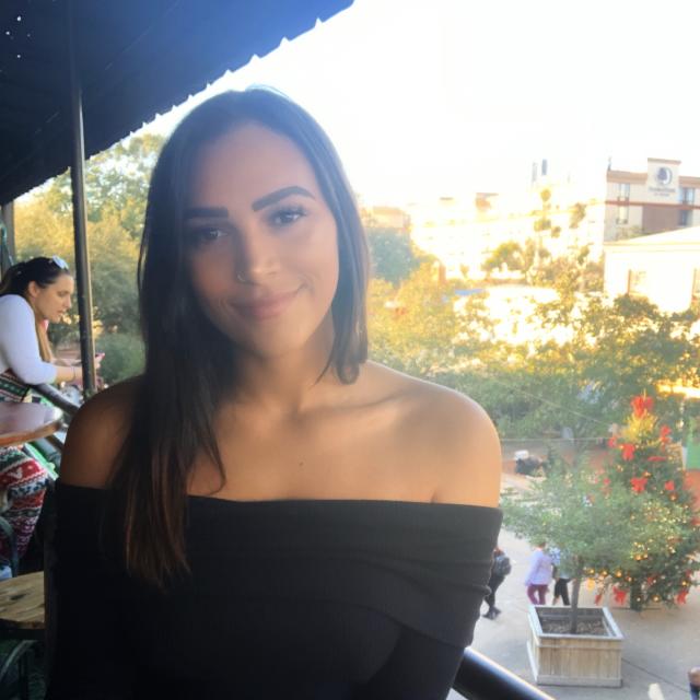 Woman wearing black shirt poses on balcony