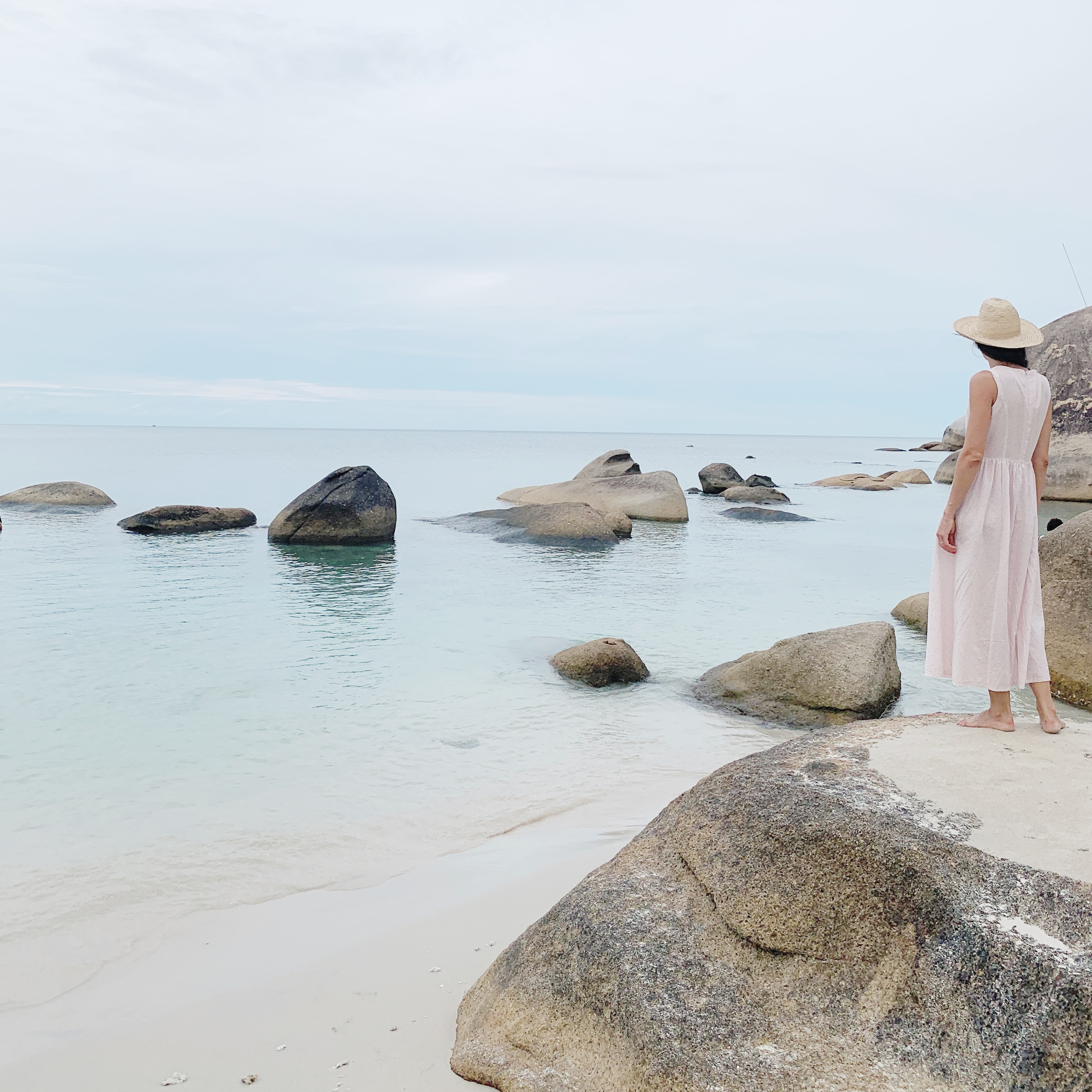 woman wearing white dress next to body of water