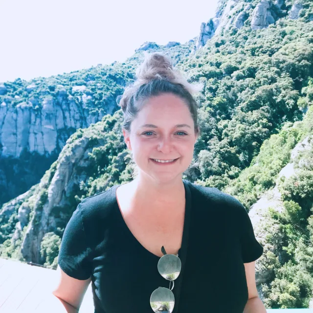 Travel Advisor Sarah Shafer smiling in front of a picturesque mountain range.