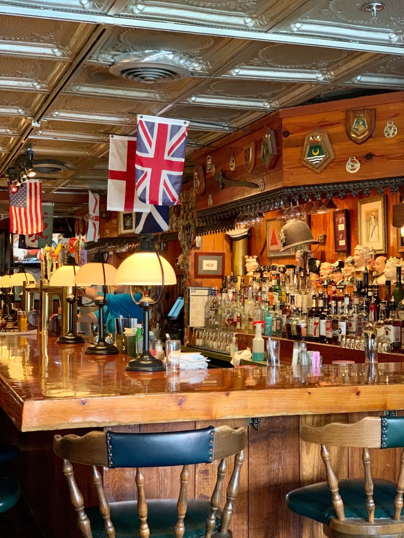 Wooden bar with England and American flags hanging with bottles of liquor in Savannah, Georgia