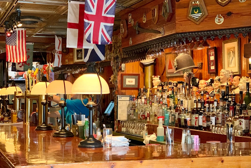 Wooden bar with England and American flags hanging with bottles of liquor in Savannah, Georgia