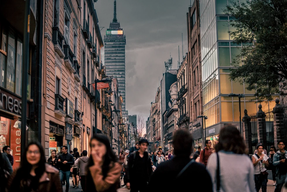 Downtown Mexico City with people on streets at night time.
