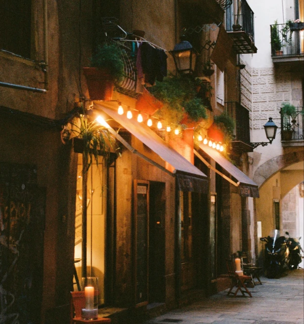 restaurant on gothic quarter city street with lights over a red awning 