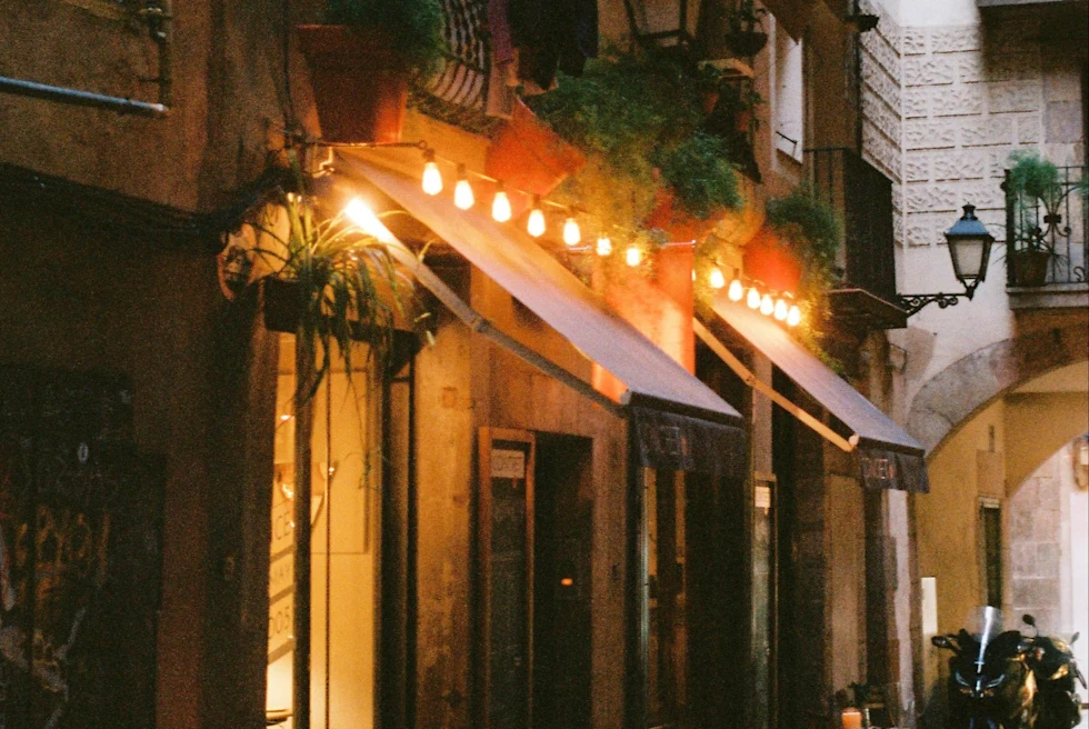 restaurant on gothic quarter city street with lights over a red awning