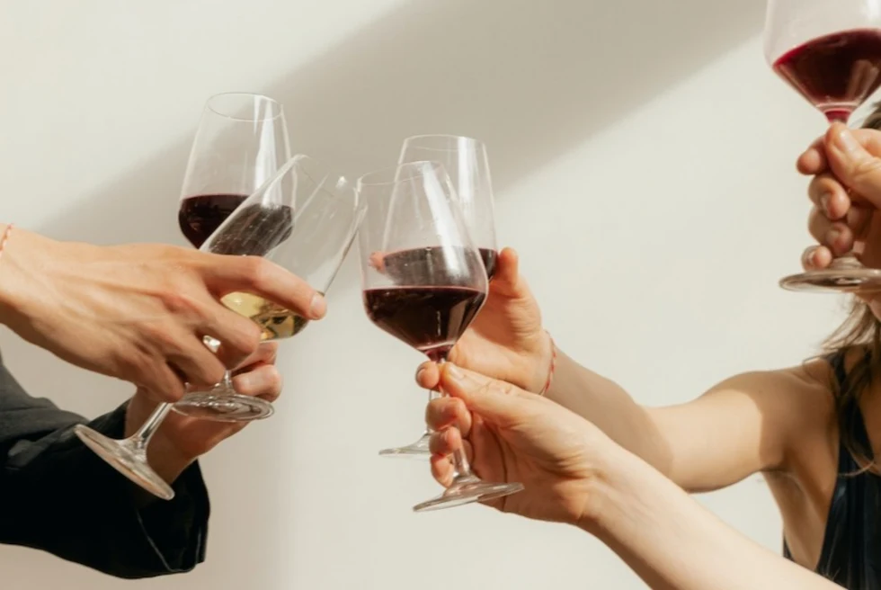 people cheers-ing glasses of red wine