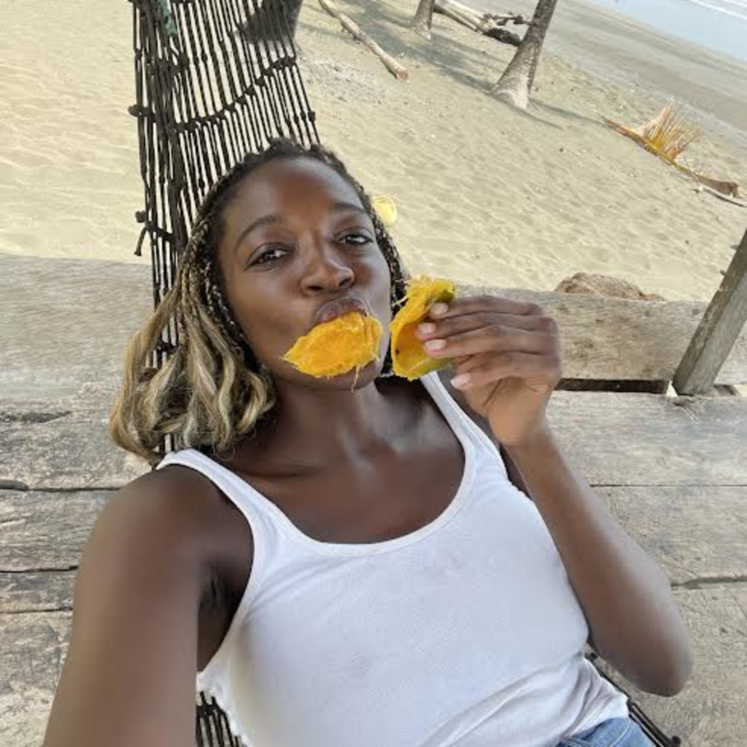 Travel advisor lying on a swing and eating mango