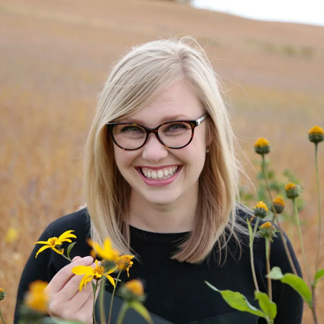 Travel advisor Vanessa Abbe smiling with yellow flowers in her hands.