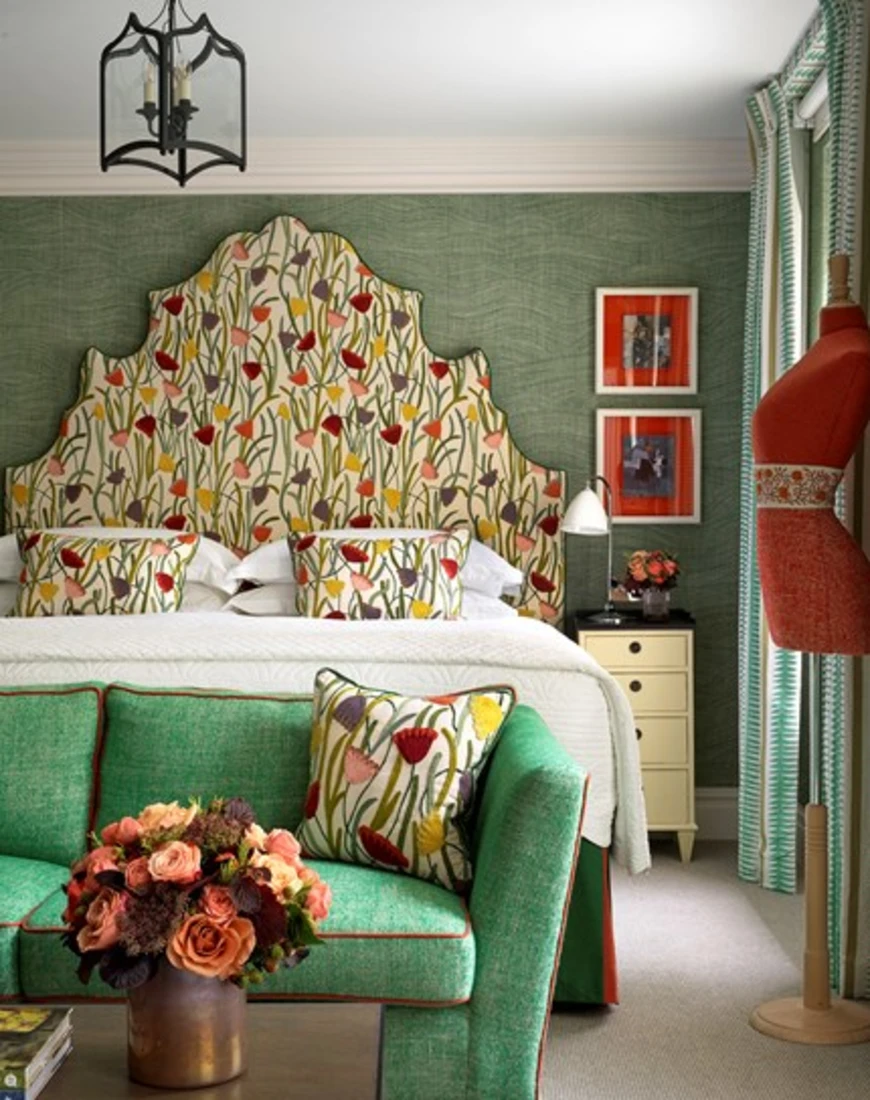 a bed with an oversized headboard covered in floral fabric