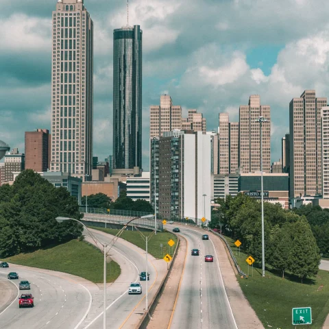 Aerial view of city buildings with highway during daytime.