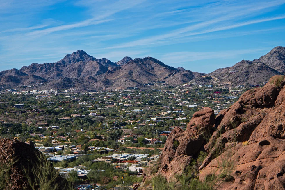 Mountains surrounding a city with trees on a sunny day