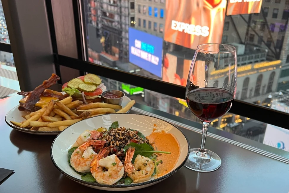 View from a lounge in Times Square with food and a glass of wine. 