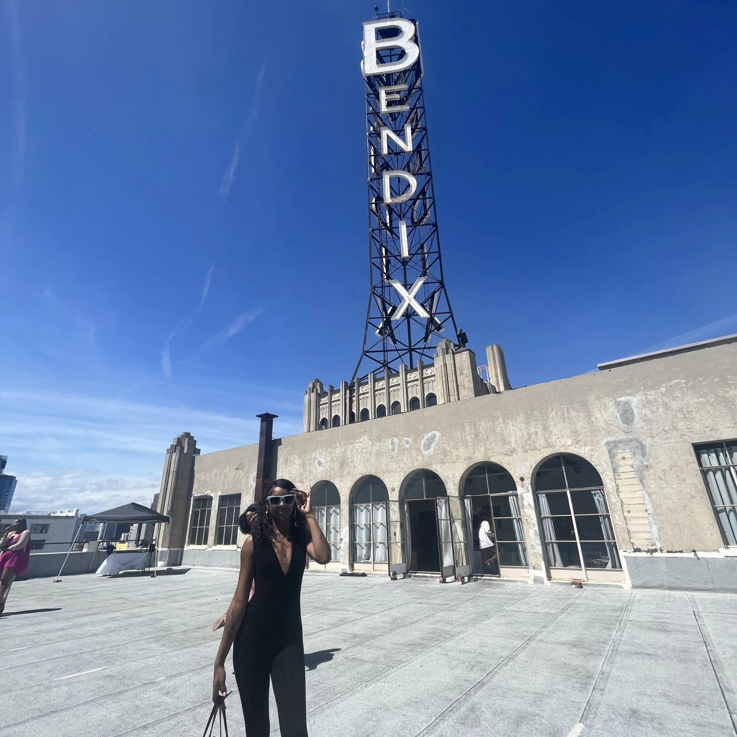 woman poses in front of building