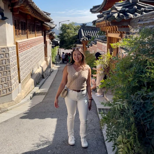 Travel advisor posing in a street with ancient temples on either side.