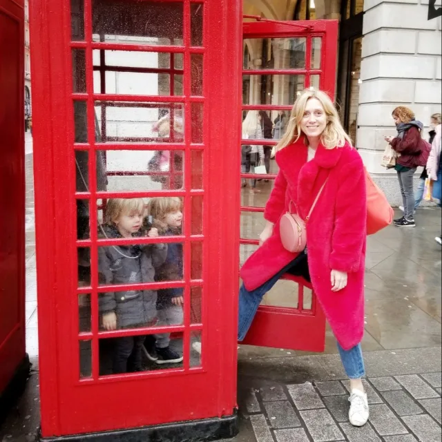 Travel advisor posing with a phone booth