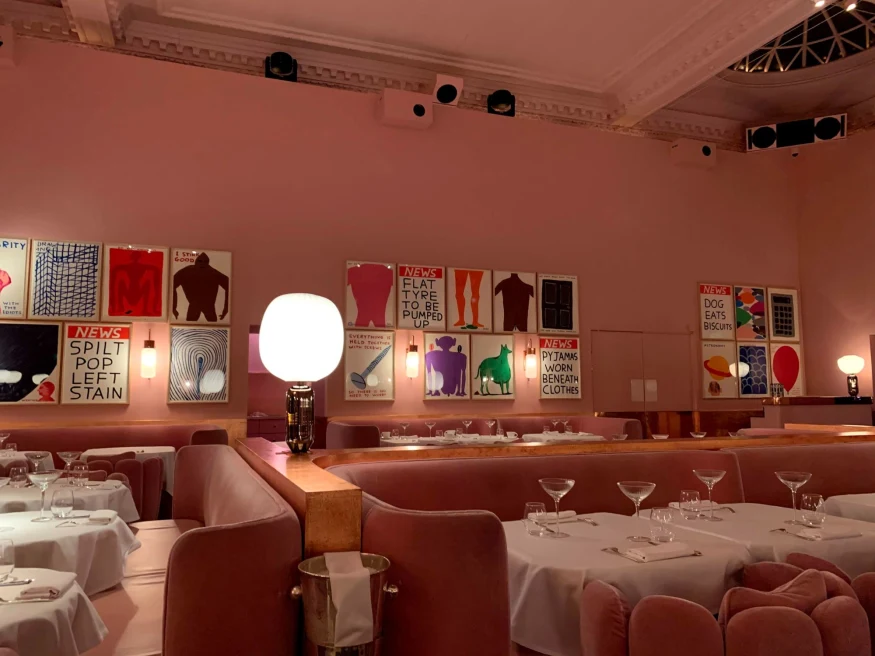 pink restaurant with contemporary art and white table clothes