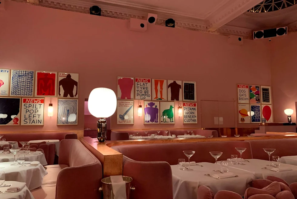 pink restaurant with contemporary art and white table clothes