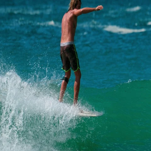 A picture of a man surfing on sea waves during daytime.
