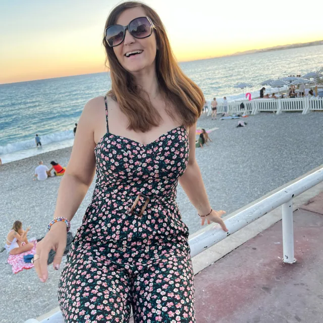 Picture of Sandy in black floral dress on a beach