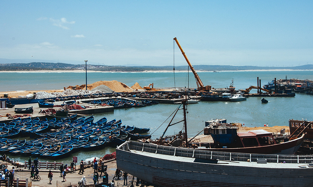 Morocco Essouria seaside with blue boats and construction yellow crane