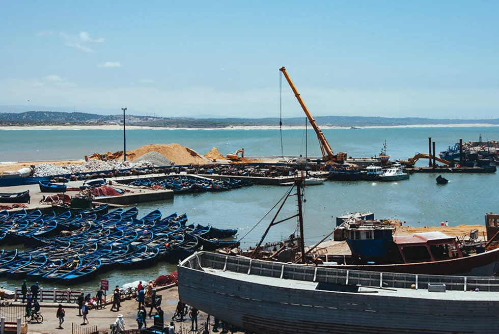 Morocco Essouria seaside with blue boats and construction yellow crane