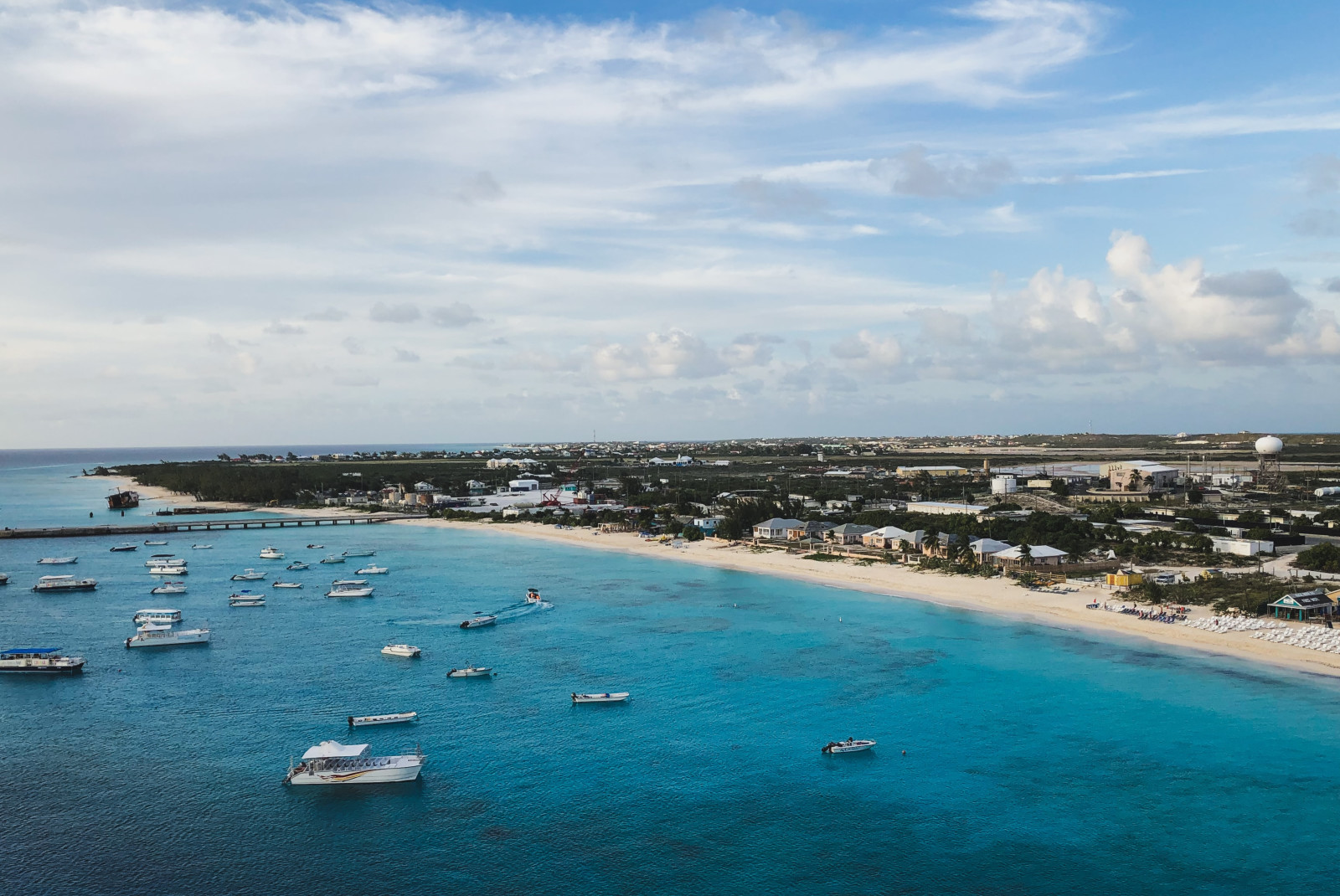 Body of water with boats next to beach during daytime