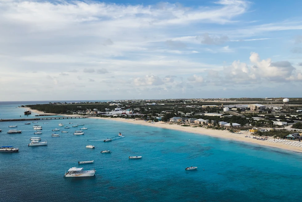 Body of water with boats next to beach during daytime