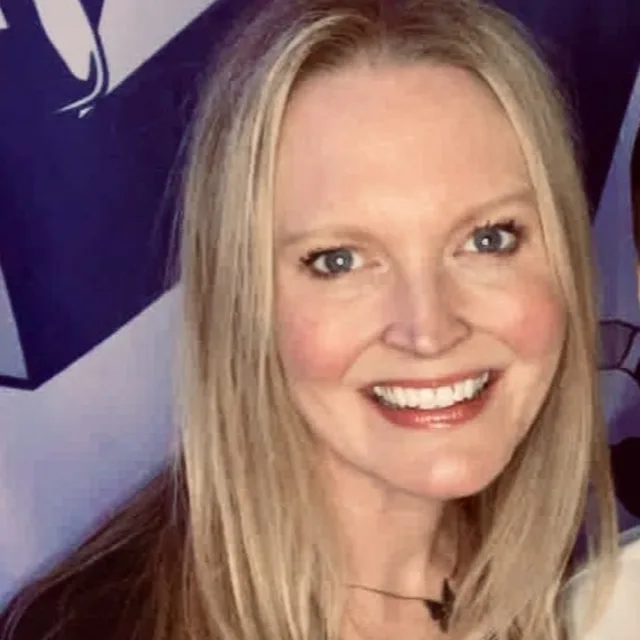 Jennifer Hoffman posing for a photo in front of a purple wall