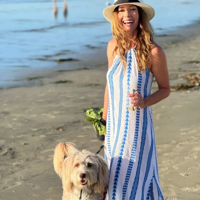 Travel Advisor Caroline Helsing is walking at the beach with her dog,