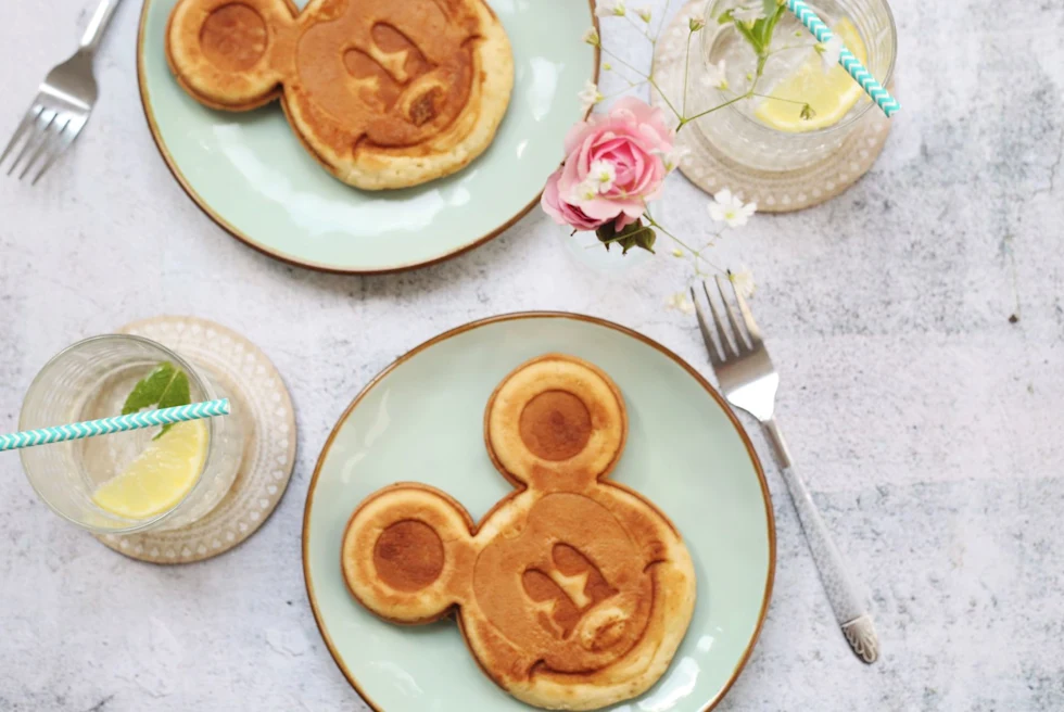 Two mickey mouse shaped pancakes.