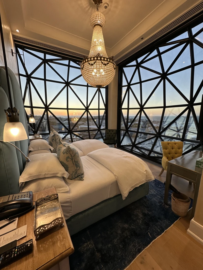 Inside one of the bedrooms in the Royal Suite at The Silo Hotel, with floor-ceiling glass walls and a view of Cape Town below.

