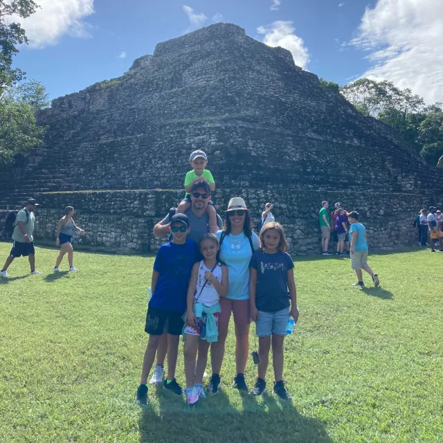 Travel Advisor Tara Neff with her family in front of a ruin.