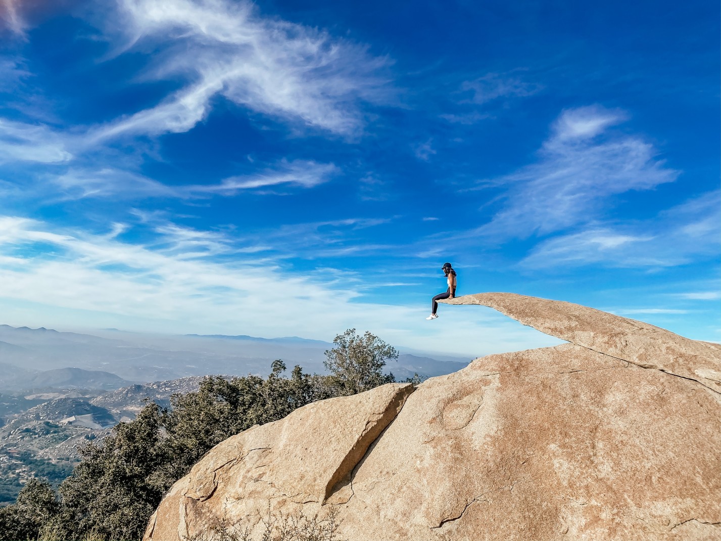 Person sitting on Potato Chip Rock on a sunny day in San Diego, California