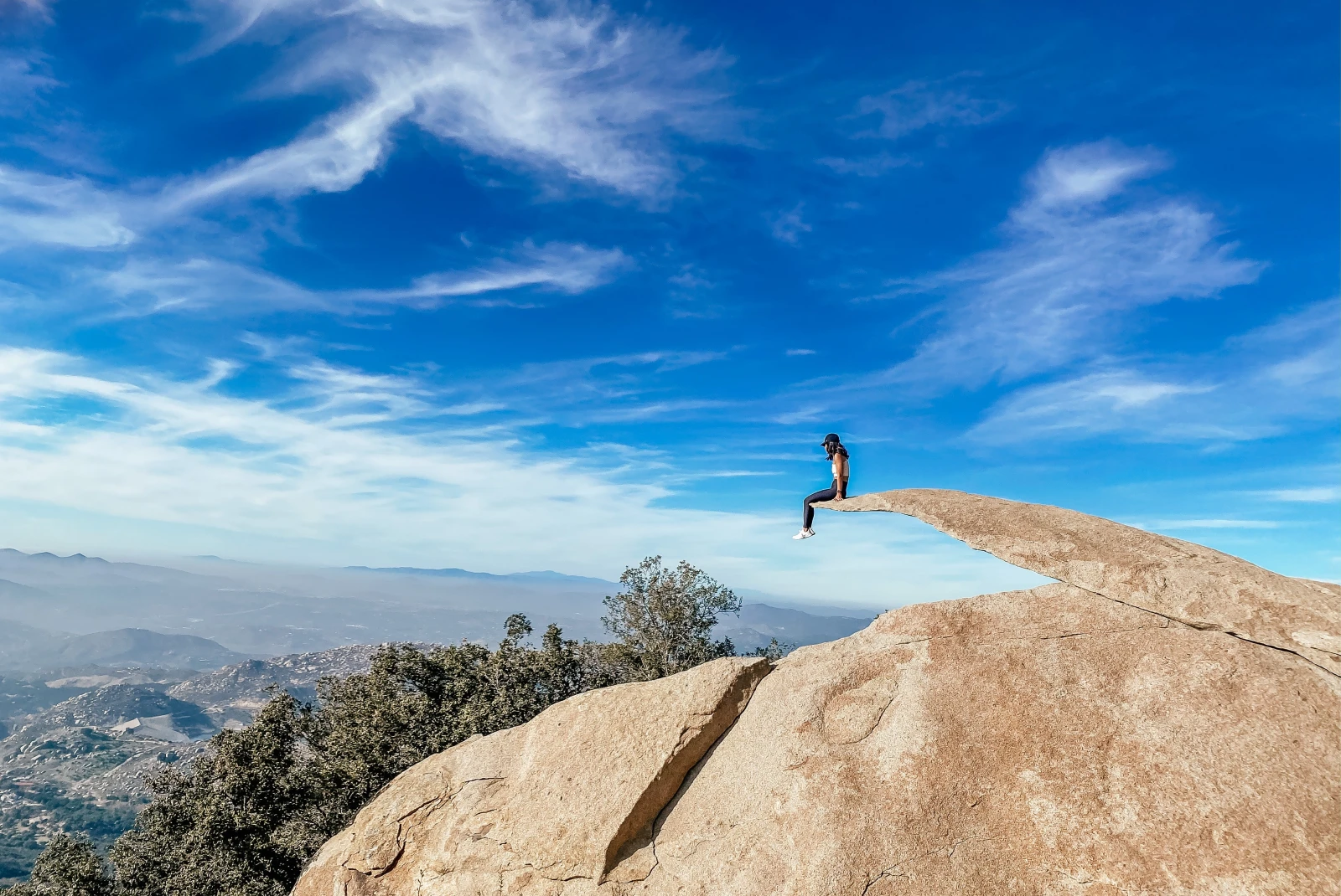 Person sitting on Potato Chip Rock on a sunny day in San Diego, California