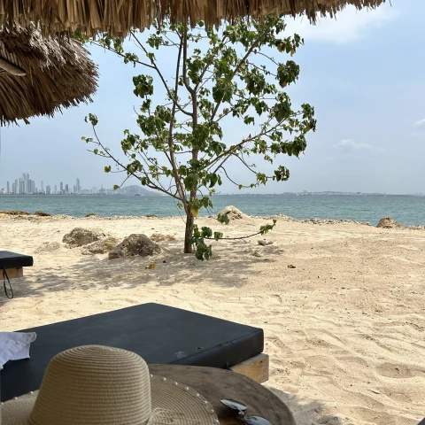 a hat on a beach table under umbrella 