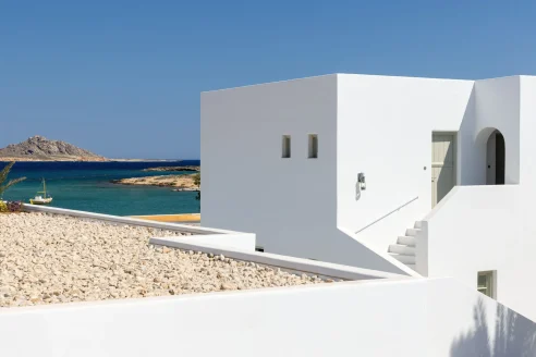 a white cube building on a sunny beach