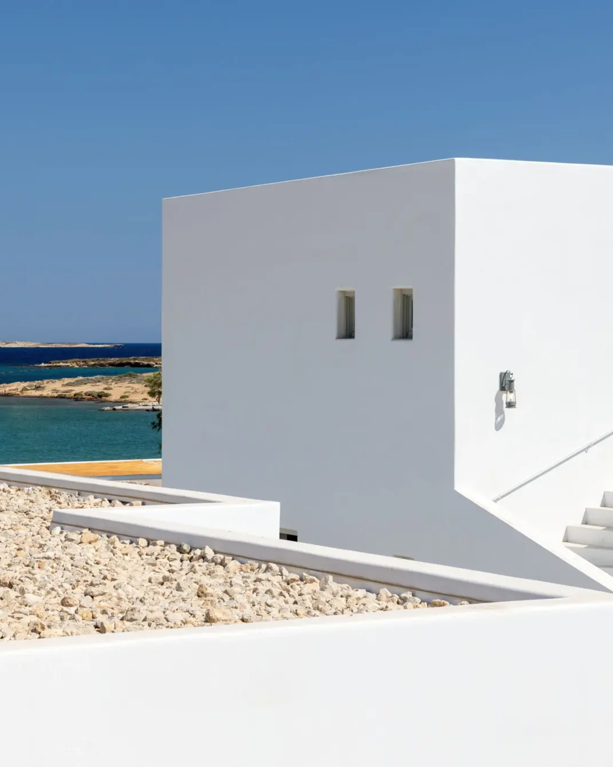 a white cube building on a sunny beach