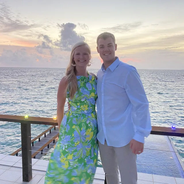 Fora travel agents Cam and Kit Lawson standing by water during sunset