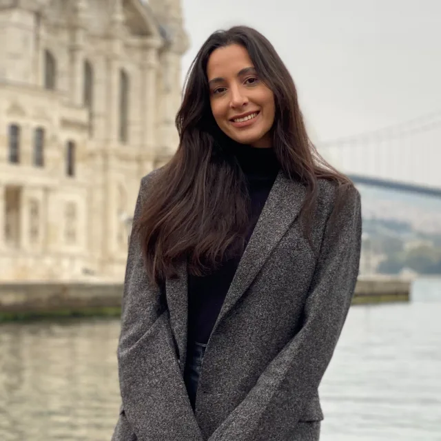 Travel advisor Ana Carolina Fontenele Pinto wearing a sport coat in front of a waterfront bridge.